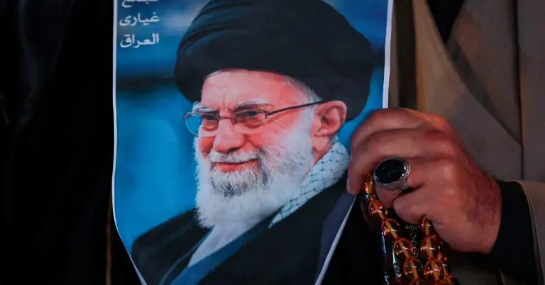 ইরানি সর্বোচ্চ নেতা আয়াতুল্লাহ আলী খামেনির পোস্টার হাতে একজন